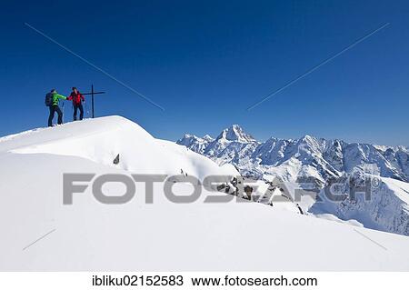 Stock Image - Two mountaineers shaking hands at the summit, Mt Torrenthorn skiing tour, Leukerbad, Valais, Switzerland, Europe. Fotosearch