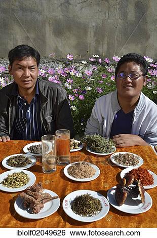 Two young Tibetan men in a cooperative producting tea and incense sticks, with ingredients for Tibetan healing herbal teas, mushrooms, herbs, flowers, spices, medicinal herbs, Tibet, China, Asia View Large Photo Image Stock Photograph - Two young Tibetan men in a cooperative producting tea and incense sticks, with ingredients for Tibetan healing herbal teas, mushrooms, herbs, flowers, spices, medicinal herbs, Tibet, China, Asia. Fotosearch