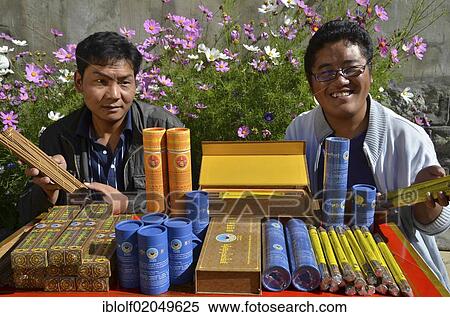 Two young Tibetan men in a cooperative producting tea and incense sticks, with the products they manufacture and differently packaged incense sticks and medicinal herbs, Tibet, China, Asia View Large Photo Image Stock Photography - Two young Tibetan men in a cooperative producting tea and incense sticks, with the products they manufacture and differently packaged incense sticks and medicinal herbs, Tibet, China, Asia. Fotosearch