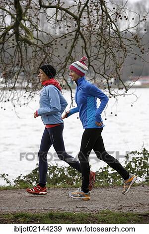 Two young women jogging in winter, wearing wind and waterproof performance apparel View Large Photo Image Stock Photo - Two young women jogging in winter, wearing wind and waterproof performance apparel. Fotosearch