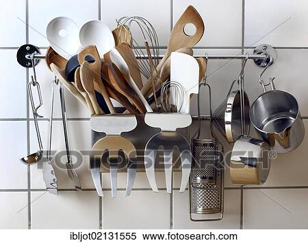 Stock Photography - Various kitchen tools and utensils, hanging on a wall in a kitchen. Fotosearch