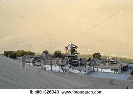 Stock Photo - View from the sand dunes of the Gobi Desert to the Crescent Lake with a Chinese pagoda near Dunhuang, Silk Road, Gansu, China, Asia. Fotosearch
