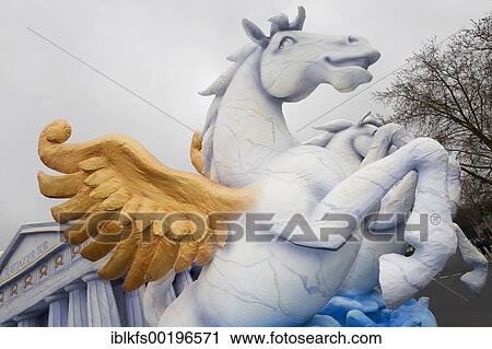 Stock Image - Winged horse jumps, figure made of paper maché, monday before lent parade, Duesseldorf, NRW, Germany, Europe. Fotosearch