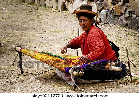 Stock Image - Woman in traditional dress weaving in the street, near Puno, Peru, South America. Fotosearch