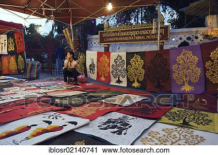 Stock Image - Woman selling pictures at a night market, Luang Prabang, Laos, Indochina, Asia. Fotosearch