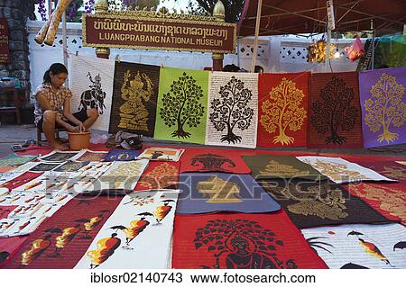 Stock Image - Woman selling pictures at a night market, Luang Prabang, Laos, Indochina, Asia. Fotosearch