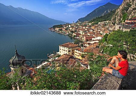Stock Photo - Woman with a view to Limone, Lake Garda, Italy, Europe. Fotosearch
