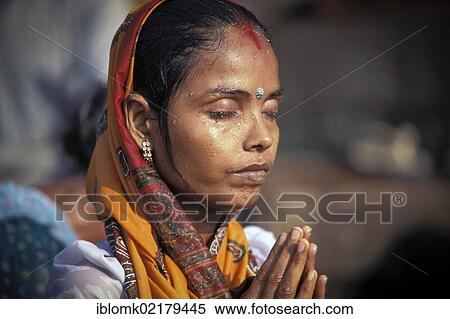Stock Photography - Woman with closed eyes in deep prayer, ritual bath, Ghats, Ganges river, Kashi, Varanasi or Benares, Uttar Pradesh, India, Asia. Fotosearch