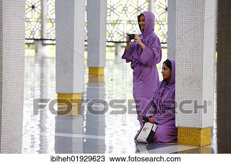 Stock Image - Women, tourists, National Mosque, Kuala Lumpur, Malaysia, Southeast Asia, Asia. Fotosearch