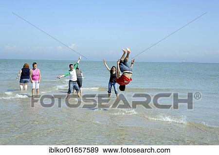 Young person somersaulting in the sea, Skagen, Jutland, Denmark, Europe View Large Photo Image Stock Photo - Young person somersaulting in the sea, Skagen, Jutland, Denmark, Europe. Fotosearch