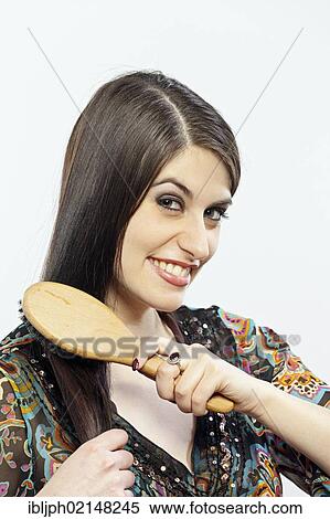 Stock Photography - Young woman brushing her hair. Fotosearch