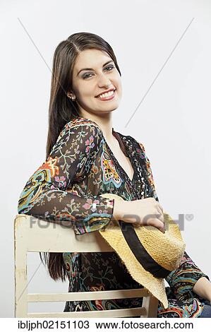 Young woman holding a hat in her hand View Large Photo Image Stock Image - Young woman holding a hat in her hand. Fotosearch
