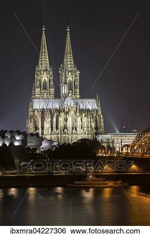 Stock Photograph - Cologne cathedral at night, Philharmonie and Hohenzollern Bridge, Rhine, Cologne, North Rhine-Westphalia, Germany, Europe. Fotosearch