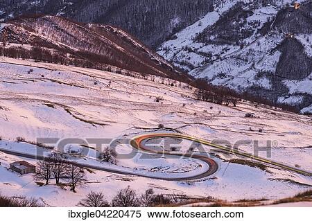 Stock Photography - Hairpin turns and light trails of a car, winter sunset on Mount Nerone, Monte Nerone in the Apennines, Marche, Italy, Europe. Fotosearch