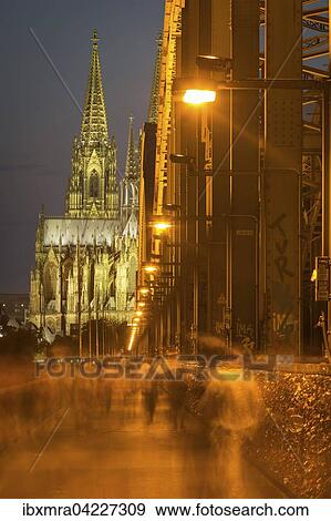 Hohenzollern Bridge at night with pedestrians, Cologne cathedral behind, Cologne, North Rhine-Westphalia, Germany, Europe View Large Photo Image Stock Photo - Hohenzollern Bridge at night with pedestrians, Cologne cathedral behind, Cologne, North Rhine-Westphalia, Germany, Europe. Fotosearch