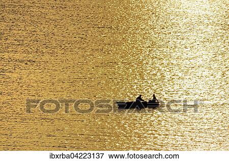 Rowing boat with two people, at sunset, Achterwasser, Usedom Island, Mecklenburg-Western Pomerania, Germany, Europe View Large Photo Image Stock Photo - Rowing boat with two people, at sunset, Achterwasser, Usedom Island, Mecklenburg-Western Pomerania, Germany, Europe. Fotosearch