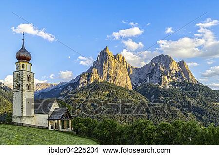 San Valentino church in front of the Schlern and moon at sunset, Siusi allo Sciliar, Castelrotto, Dolomites, Italy, Europe View Large Photo Image Picture - San Valentino church in front of the Schlern and moon at sunset, Siusi allo Sciliar, Castelrotto, Dolomites, Italy, Europe. Fotosearch