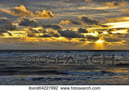 Stock Image - Sunset with clouds on the beach, North Sea, Texel, West Frisian Islands, Province of North Holland, The Netherlands, Europe. Fotosearch