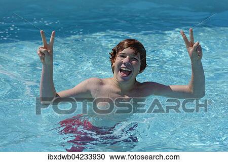 Teenage boy in the water, happy, peace sign, victory sign, in a swimming pool View Large Photo Image Stock Image - Teenage boy in the water, happy, peace sign, victory sign, in a swimming pool. Fotosearch