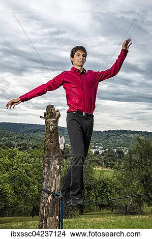 Young man balancing on slackline, 20 years View Large Photo Image Picture - Young man balancing on slackline, 20 years. Fotosearch