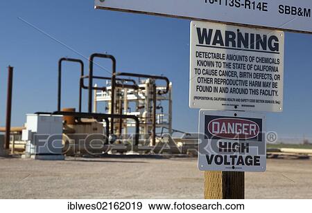 Stock Photo - A sign warns of cancer-causing chemicals at a well for a geothermal energy plant in California's Imperial Valley, Brawley, California, USA, North America. Fotosearch
