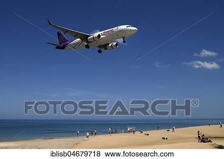 Airplane Smile Air landing over sandy beach, Mai Kao Beach, Phuket, Thailand, Asia View Large Photo Image Stock Photo - Airplane Smile Air landing over sandy beach, Mai Kao Beach, Phuket, Thailand, Asia. Fotosearch