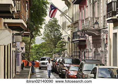 Stock Image - Alley in the historic town centre of San Juan with a Puerto Rican and a U. S. flag, San Juan, Puerto Rico, an unincorporated territory of the United States, North America. Fotosearch