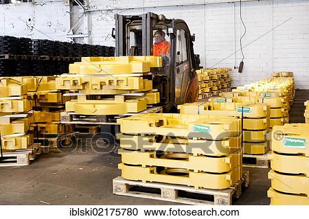 An employee of the Luitpoldhuette AG, a foundry that specializes in the casting of engine blocks, motor parts and refrigeration compressors, transporting ballast weights in a warehouse, in Amberg, Bavaria, Germany, Europe View Large Photo Image Stock Image - An employee of the Luitpoldhuette AG, a foundry that specializes in the casting of engine blocks, motor parts and refrigeration compressors, transporting ballast weights in a warehouse, in Amberg, Bavaria, Germany, Europe. Fotosearch