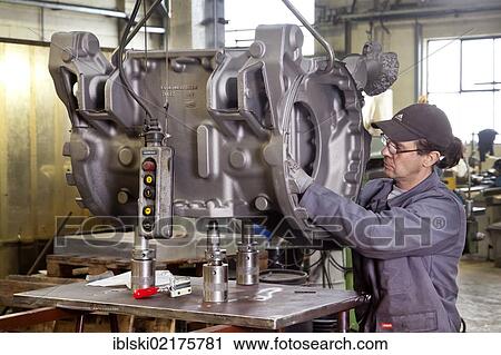 An employee of the Luitpoldhuette AG, a foundry that specializes in the casting of engine blocks, motor parts and refrigeration compressors, controlling a cast rear axle, in Amberg, Bavaria, Germany, Europe View Large Photo Image Stock Image - An employee of the Luitpoldhuette AG, a foundry that specializes in the casting of engine blocks, motor parts and refrigeration compressors, controlling a cast rear axle, in Amberg, Bavaria, Germany, Europe. Fotosearch