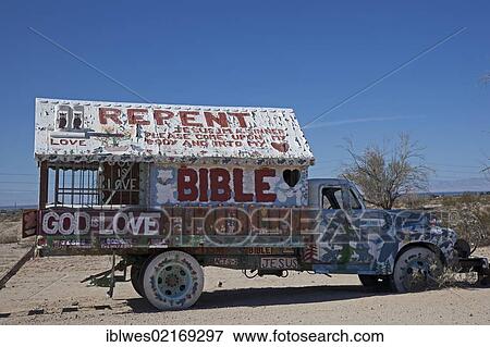 Stock Photo - An old truck decorated with religious slogans on the property of Salvation Mountain, a desert hillside covered with religious messages, created by Leonard Knight, Niland, California, USA, North America. Fotosearch