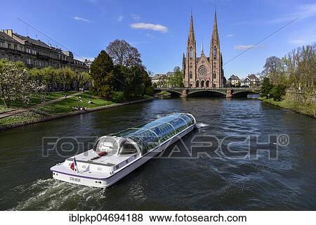 Stock Photo - Boat on river Ill with St. Paul's Church, Strasbourg, Alsace, France, Europe. Fotosearch