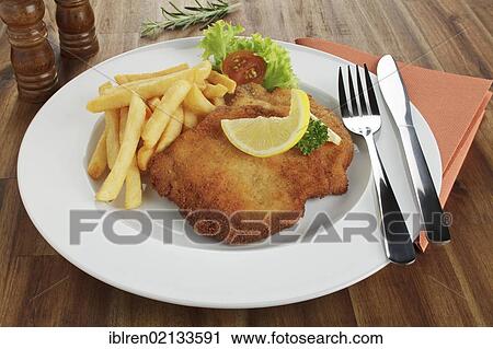 Breaded pork escalope Viennese style with lemon slice and French fries View Large Photo Image Stock Image - Breaded pork escalope Viennese style with lemon slice and French fries. Fotosearch