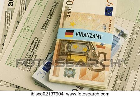 Bundle of euro banknotes bound with a label for Finanzamt, German for tax office, on income tax return forms, symbolic image for income tax View Large Photo Image Picture - Bundle of euro banknotes bound with a label for Finanzamt, German for tax office, on income tax return forms, symbolic image for income tax. Fotosearch