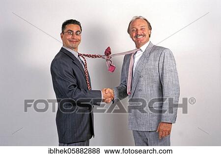 Stock Photo - Businessmen shake hands, funny, tie knotted, Berlin, Germany, Europe. Fotosearch