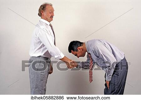 Businessmen shaking hands, funny, deep bow, submissive, Berlin, Germany, Europe View Large Photo Image Stock Photograph - Businessmen shaking hands, funny, deep bow, submissive, Berlin, Germany, Europe. Fotosearch