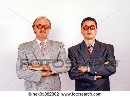 Stock Image - Businessmen with tomatoes on their eyes, serious face, funny, blind, Berlin, Germany, Europe. Fotosearch