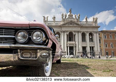 Stock Image - Cadillac in front of the facade of the Basilica San Giovanni in Laterano, Rome, Italy, Europe. Fotosearch