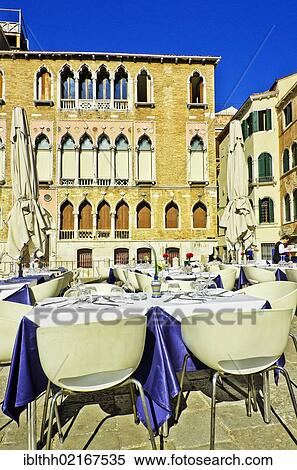Chairs and tables outside a restaurant in Venice, Venezia, Veneto, Italy, Europe View Large Photo Image Stock Photography - Chairs and tables outside a restaurant in Venice, Venezia, Veneto, Italy, Europe. Fotosearch