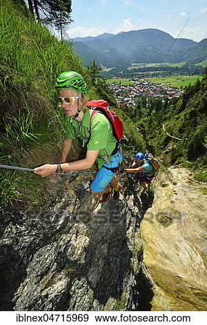 Stock Photo - Climbers at rock face, via ferrata Hausbachfall, Reit im Winkl, Chiemgau, Bavaria, Germany, Europe. Fotosearch