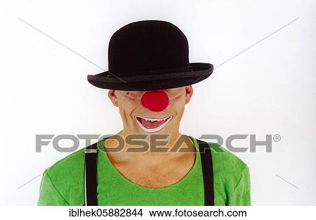 Picture - Clown, red nose, hat on face, laughing, Berlin, Germany, Europe. Fotosearch