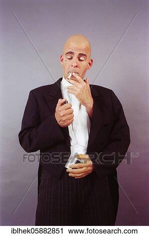 Stock Image - Clown with three hands, lights a cigarette, Berlin, Germany, Europe. Fotosearch