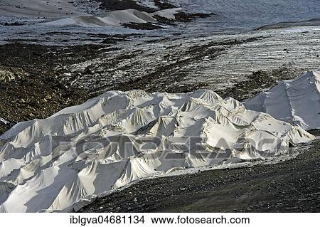 Covering of glacier ice with white plastic fleece to reduce glacier shrinkage in summer, skiing area Kaunertal Glacier, Kaunertal, Ötztaler Alps, Tyrol, Austria, Europe View Large Photo Image Picture - Covering of glacier ice with white plastic fleece to reduce glacier shrinkage in summer, skiing area Kaunertal Glacier, Kaunertal, Ötztaler Alps, Tyrol, Austria, Europe. Fotosearch