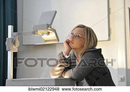 Stock Photo - Demotivated trainee teacher, prospective teacher, young teacher, classroom, overhead projector, Baden-Wuerttemberg, Germany, Europe. Fotosearch