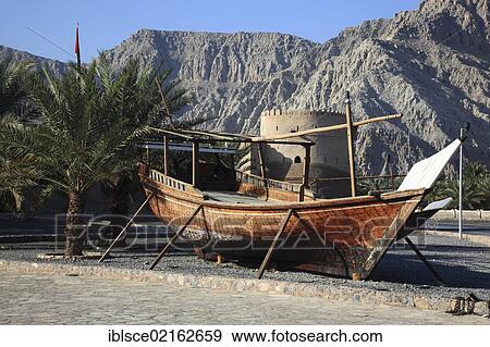 Stock Photo - Dhow, a traditional wooden boat, in front of Cacapo Fort, al-Khasab, Khasab, in the Omani enclave of Musandam, Oman, Middle East, Asia. Fotosearch