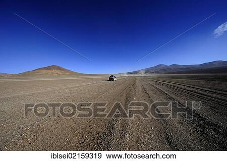 Stock Photo - Dirt road with a jeep, Uyuni, Bolivia, South America. Fotosearch