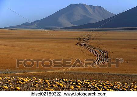 Stock Image - Dirt road with a volcano, Desierto, Uyuni, Bolivia, South America. Fotosearch