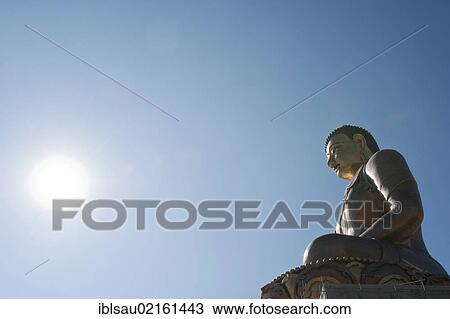 Stock Image - Enlightenment, Tibetan Buddhism, the Big Buddha Statue, big Buddha looking into the light, bronze statue, Thimphu, the Himalayas, Kingdom of Bhutan, South Asia, Asia. Fotosearch