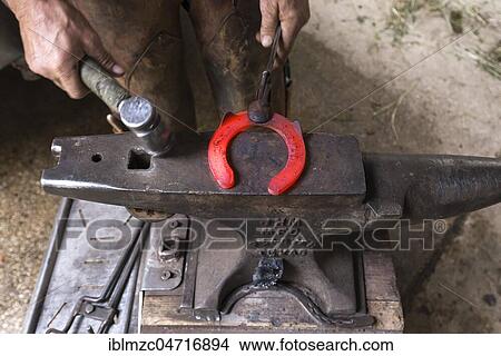 Picture - Farrier shapes a glowing horseshoe on an anvil, Bavaria, Germany, Europe. Fotosearch
