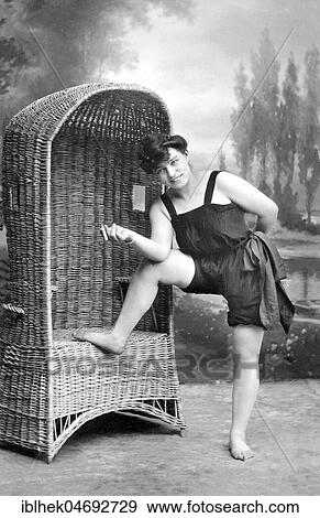 Fashion, swimwear, woman with cigarette and in bathing clothes standing in front of a beach chair, 1910s, Germany, Europe View Large Photo Image Stock Photo - Fashion, swimwear, woman with cigarette and in bathing clothes standing in front of a beach chair, 1910s, Germany, Europe. Fotosearch