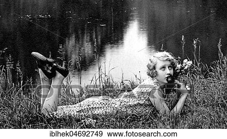 Fashion, Woman in summer dress in grass on a lake, 1920s, Germany, Europe View Large Photo Image Stock Photo - Fashion, Woman in summer dress in grass on a lake, 1920s, Germany, Europe. Fotosearch